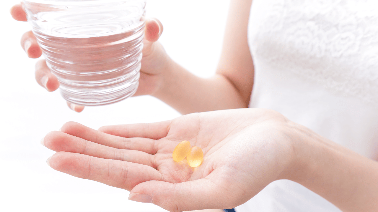 コップと錠剤を持ってる人